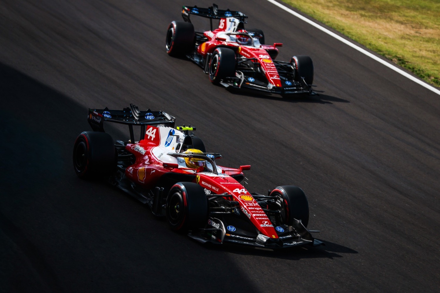 Two Scuderia Ferrari Formula 1 cars running nose to tail on track